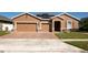 Stunning single-story home boasting a 3-car garage, solar panels, and a beautifully paved driveway and walkway at 1855 Partin Terrace Rd, Kissimmee, FL 34744