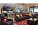 Comfortable living room with a view into the kitchen offering a dark leather reclining sofa and a patterned red rug at 1855 Partin Terrace Rd, Kissimmee, FL 34744