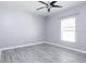 Cozy bedroom featuring gray laminate flooring and a window, creating a serene and inviting atmosphere at 188 Whispering Pines Way, Davenport, FL 33837