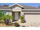 Inviting home exterior with a paver driveway, a two-car garage, and lush landscaping at 188 Whispering Pines Way, Davenport, FL 33837