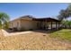 Home exterior featuring desert landscaping, a covered patio and solar panels on the roof at 188 Whispering Pines Way, Davenport, FL 33837