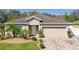 Charming single-story home featuring a well-maintained lawn, paver driveway, and an attached two-car garage at 188 Whispering Pines Way, Davenport, FL 33837