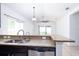 Kitchen with stainless steel appliances, granite counters, dark wood cabinets, open to living area at 188 Whispering Pines Way, Davenport, FL 33837