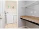 Functional laundry area with washer, dryer, shelving, and a countertop for folding at 188 Whispering Pines Way, Davenport, FL 33837