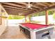 Spacious covered patio featuring a wooden pergola, a pool table, and a well-maintained outdoor space at 188 Whispering Pines Way, Davenport, FL 33837