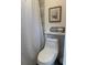 Cozy bathroom featuring a toilet, shower with curtain, and decorative wall art at 1955 Mustang Ct, St Cloud, FL 34771