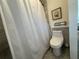 Compact bathroom featuring a toilet, shower with curtain, and decorative accents at 1955 Mustang Ct, St Cloud, FL 34771