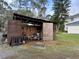 Open-sided equipment shed housing a riding lawnmower and various outdoor tools at 1955 Mustang Ct, St Cloud, FL 34771