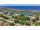 Aerial view of a home near a canal, featuring green trees and a waterfront backdrop with recreational boating at 24 Cypress Ave, St Cloud, FL 34769
