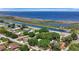 Aerial view of a home near a canal, featuring green trees and a waterfront backdrop with recreational boating at 24 Cypress Ave, St Cloud, FL 34769