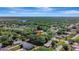 Aerial view of property surrounded by trees in a residential area, featuring a nearby lake and lush greenery at 24 Cypress Ave, St Cloud, FL 34769