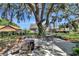 Serene backyard featuring lush landscaping, a mature tree, and outdoor seating for entertaining at 24 Cypress Ave, St Cloud, FL 34769