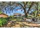 Spacious backyard with a large shade tree and outdoor seating, perfect for relaxation at 24 Cypress Ave, St Cloud, FL 34769