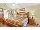 Spacious bedroom featuring a large bed, wooden furniture, ceiling fan, and ensuite bath access at 24 Cypress Ave, St Cloud, FL 34769
