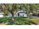 Charming one-story home featuring mature landscaping, arched windows, and a welcoming front entrance at 24 Cypress Ave, St Cloud, FL 34769
