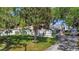 Charming home with a well-manicured lawn, mature trees, and stylish gray exterior, complete with solar panels and lovely landscaping at 24 Cypress Ave, St Cloud, FL 34769