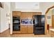 Kitchen showcasing wood cabinetry, a black refrigerator, and tile backsplash, offering a blend of style and utility at 24 Cypress Ave, St Cloud, FL 34769
