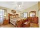 Comfortable main bedroom with wooden furniture, ceiling fan, and good natural light at 24 Cypress Ave, St Cloud, FL 34769