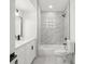 Bright bathroom featuring a shower-tub combo with marble tile, updated fixtures, and ample lighting at 2555 Sweetwater Trl, Maitland, FL 32751