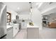 Open kitchen with white cabinets, stainless appliances, and view to a living room featuring a fireplace at 2555 Sweetwater Trl, Maitland, FL 32751