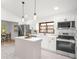 Bright kitchen featuring a center island, stainless steel appliances, and an adjacent dining area at 2555 Sweetwater Trl, Maitland, FL 32751
