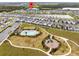 An aerial view of the neighborhood highlighting the community pool, playground, and nearby lake at 261 Whistling Duck Trl, St Cloud, FL 34771