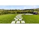 Expansive backyard featuring manicured lawn, stepping stone pathway and pergola at 261 Whistling Duck Trl, St Cloud, FL 34771