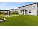 Spacious backyard with well-manicured lawn, pavers, and a modern pergola at 261 Whistling Duck Trl, St Cloud, FL 34771