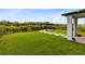 Lush backyard showcasing manicured lawn, stone tile pathway, and a serene pergola at 261 Whistling Duck Trl, St Cloud, FL 34771