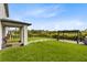 Lush backyard featuring manicured lawn, covered patio, and stone tile pathway leading to a pergola at 261 Whistling Duck Trl, St Cloud, FL 34771