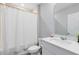 Clean, white bathroom featuring a shower, toilet, and modern sink with quartz countertop at 261 Whistling Duck Trl, St Cloud, FL 34771