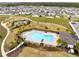 Aerial shot of a community pool area with lounge chairs, palm trees, and a nearby playground at 261 Whistling Duck Trl, St Cloud, FL 34771