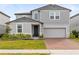 Charming two-story home with brick driveway, landscaped yard, and attached two-car garage at 261 Whistling Duck Trl, St Cloud, FL 34771