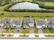 Street view of modern homes with well-maintained lawns and brick driveways near a serene lake at 261 Whistling Duck Trl, St Cloud, FL 34771