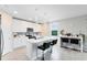 Well-lit kitchen featuring a center island with bar seating, mosaic backsplash, and white cabinetry at 261 Whistling Duck Trl, St Cloud, FL 34771