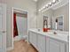 Bright bathroom featuring a double sink vanity, tile flooring, and a door to the toilet and shower at 2954 Willow Bay Ter, Casselberry, FL 32707