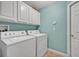 Clean laundry room with white washer and dryer, overhead cabinets, and pale blue walls at 2954 Willow Bay Ter, Casselberry, FL 32707