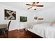 Comfortable bedroom featuring wood floors, a ceiling fan, a desk and a large scrabble-style artwork at 2991 Timpana Pt, Longwood, FL 32779