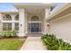 Stunning front entrance with a grand doorway framed by elegant columns and lush landscaping at 2991 Timpana Pt, Longwood, FL 32779