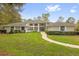 Expansive single-story home with well-manicured lawn, lush landscaping, and a welcoming walkway to the front door at 2991 Timpana Pt, Longwood, FL 32779