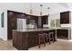 Well-equipped kitchen featuring dark cabinets, granite counters, stainless steel appliances, and a spacious island at 2991 Timpana Pt, Longwood, FL 32779