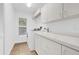 Bright laundry room featuring a washing machine, sink, and ample cabinet space, perfect for efficient household tasks at 2991 Timpana Pt, Longwood, FL 32779