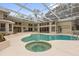 Screened-in pool and spa with clear water, surrounded by a large patio, perfect for relaxing or entertaining at 2991 Timpana Pt, Longwood, FL 32779