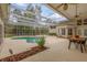 Screened-in pool area with a spa, patio furniture, lush landscaping, and seamless access from inside the home at 2991 Timpana Pt, Longwood, FL 32779