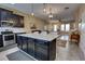 Open kitchen featuring an island with a granite countertop, stainless steel appliances, and a view into the living room at 3345 Messina Dr, Lake Mary, FL 32746