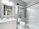 Bright bathroom featuring a glass-enclosed shower, white cabinets, and a vanity with decorative mirror at 4103 Calabria Ave, Davenport, FL 33897