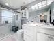 Modern bathroom features a large glass shower, beautiful marble walls, white cabinetry and decorative accents at 4103 Calabria Ave, Davenport, FL 33897