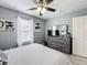 Comfortable bedroom with a ceiling fan, white blinds, stylish decor, dresser, and hardwood flooring at 4103 Calabria Ave, Davenport, FL 33897