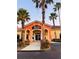 Charming commercial building with an orange and yellow color scheme and palm tree accents at 4103 Calabria Ave, Davenport, FL 33897