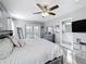 Bright bedroom with a ceiling fan, hardwood floors, double doors leading to a balcony, and a stylish ensuite bathroom at 4103 Calabria Ave, Davenport, FL 33897